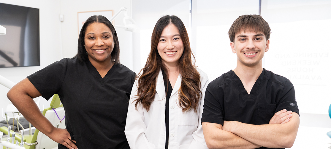 Dr. Lu smiling with two Just For Kids Dentistry dental assistants inside the dental office.